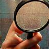 Hand holding a magnifying glass over a painting detail